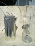 This is a picture of a Poor Man's candle holder and coffee pot. The Poor man's candle base is full of sand, so it does not tip over very easy. I then make a coffee pot to hold the lantern so it will not break when traveling. I used a furnace filter as the buffer to the glass globe. I claim the filter looks like horse hair, so it kind of period. The lamp is actually a Bask(sp) Sheep Herders candle from Spain. The tinner I got if from, said that the man's great grandfather came over to America around 1810. So it is period, just from a different country. 