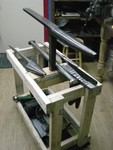 This is one picture of my stakes and associated work station. There is another picture that shows my stake station pushed under my bench. I used a mechanics crawler for the base, so I could push my stakes under my bench. I only had to put one hole in the 4 x 4 in the middle of the top, to put my stakes in. Notice, I put metal bars on either side of the 4 x 4 block, so it will reduce the splitting. 